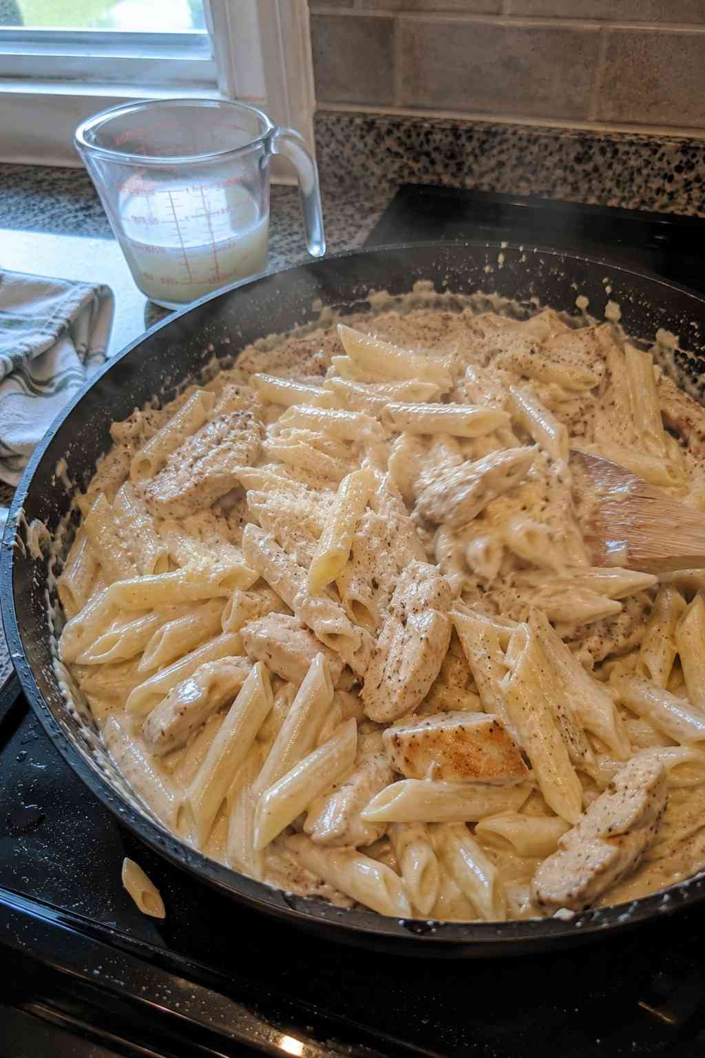 Mixing pasta chicken and sauce