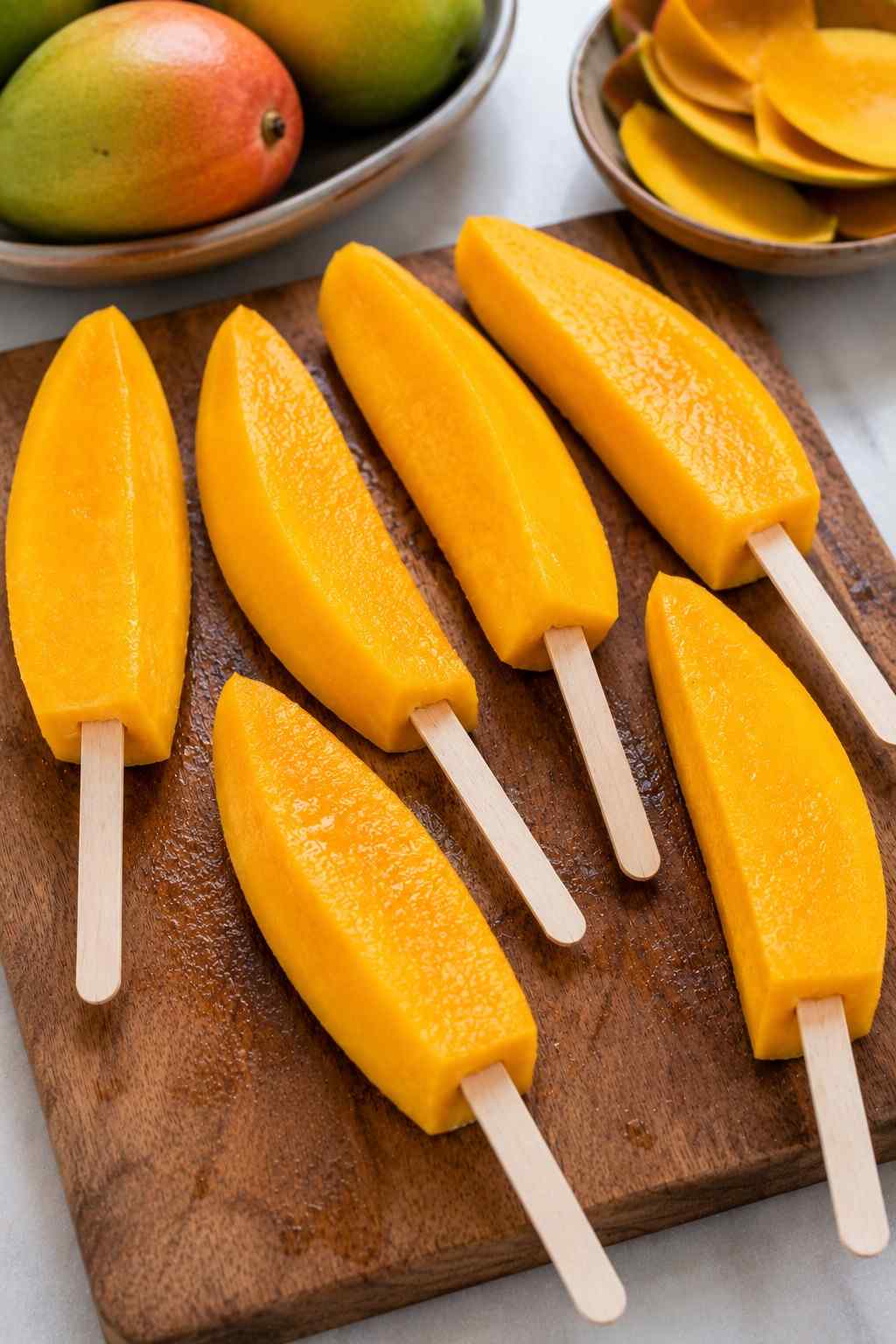 Popsicle sticks inserted into mango spears