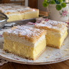 Squares of krempita with golden puff pastry, vanilla custard and whipped cream dusted with powdered sugar